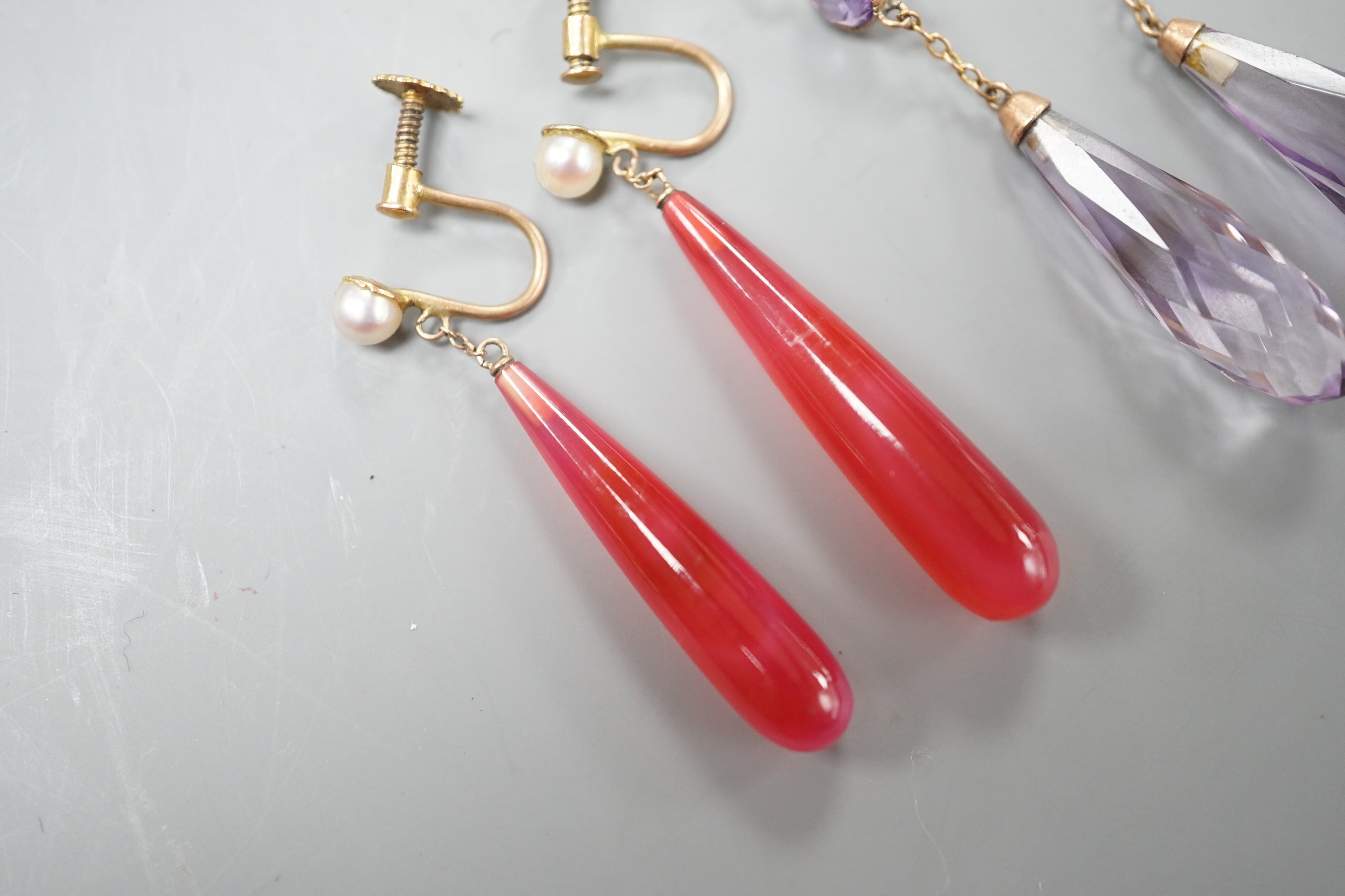 A pair of yellow metal and two facetted amethyst drop earrings, overall 49mm and a pair of 9ct, red carnelian? and seed pearl set drop earrings.